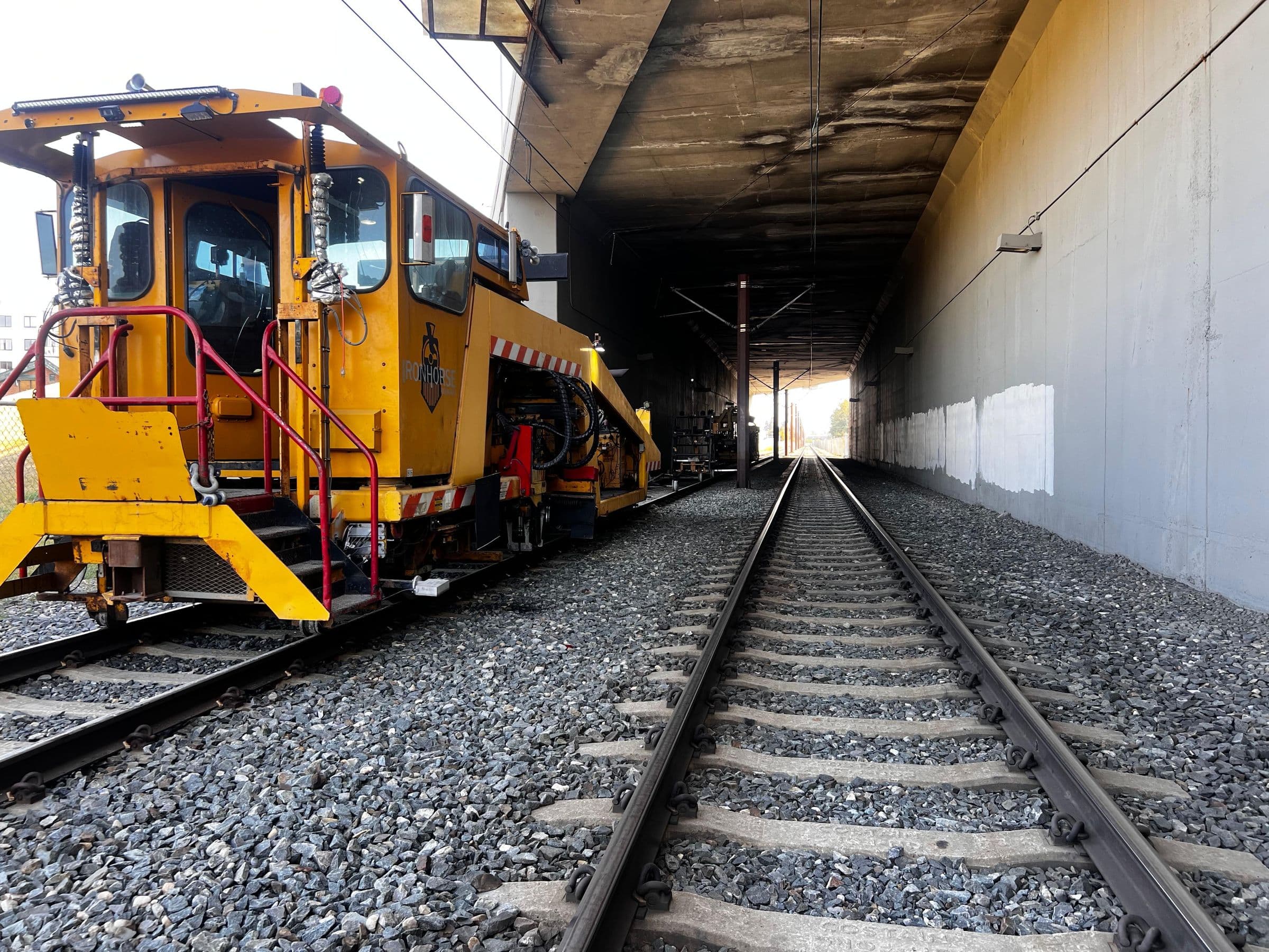 Yellow tamper on new track entering a covered section