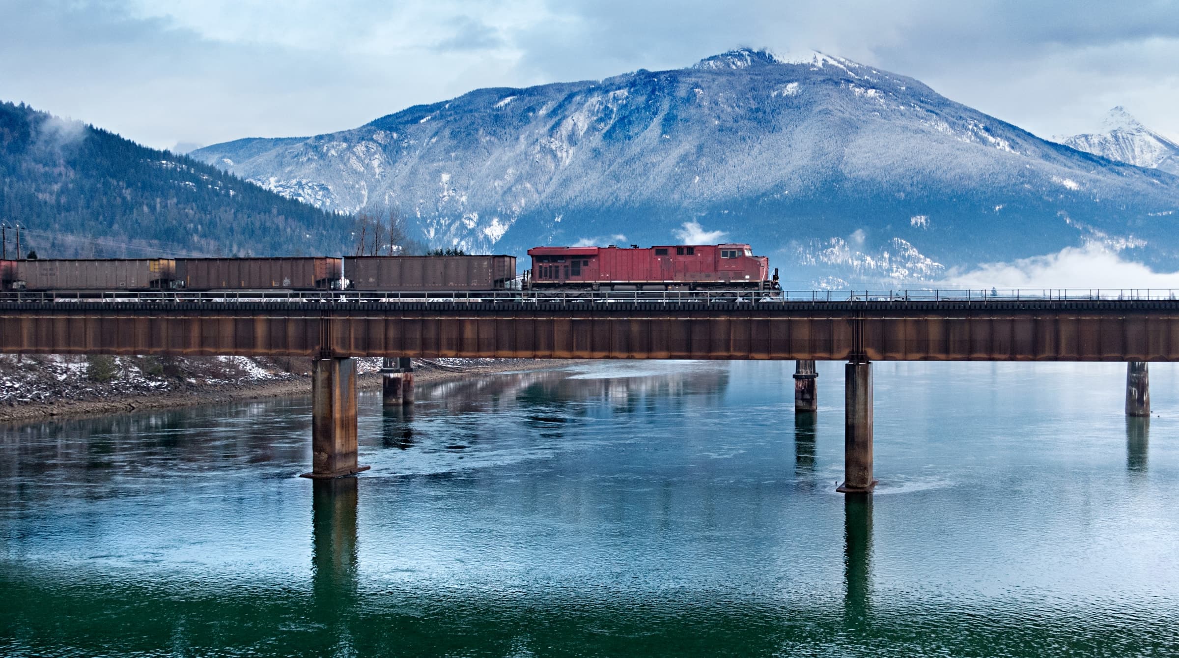 Freight railway crossing a mountain lake