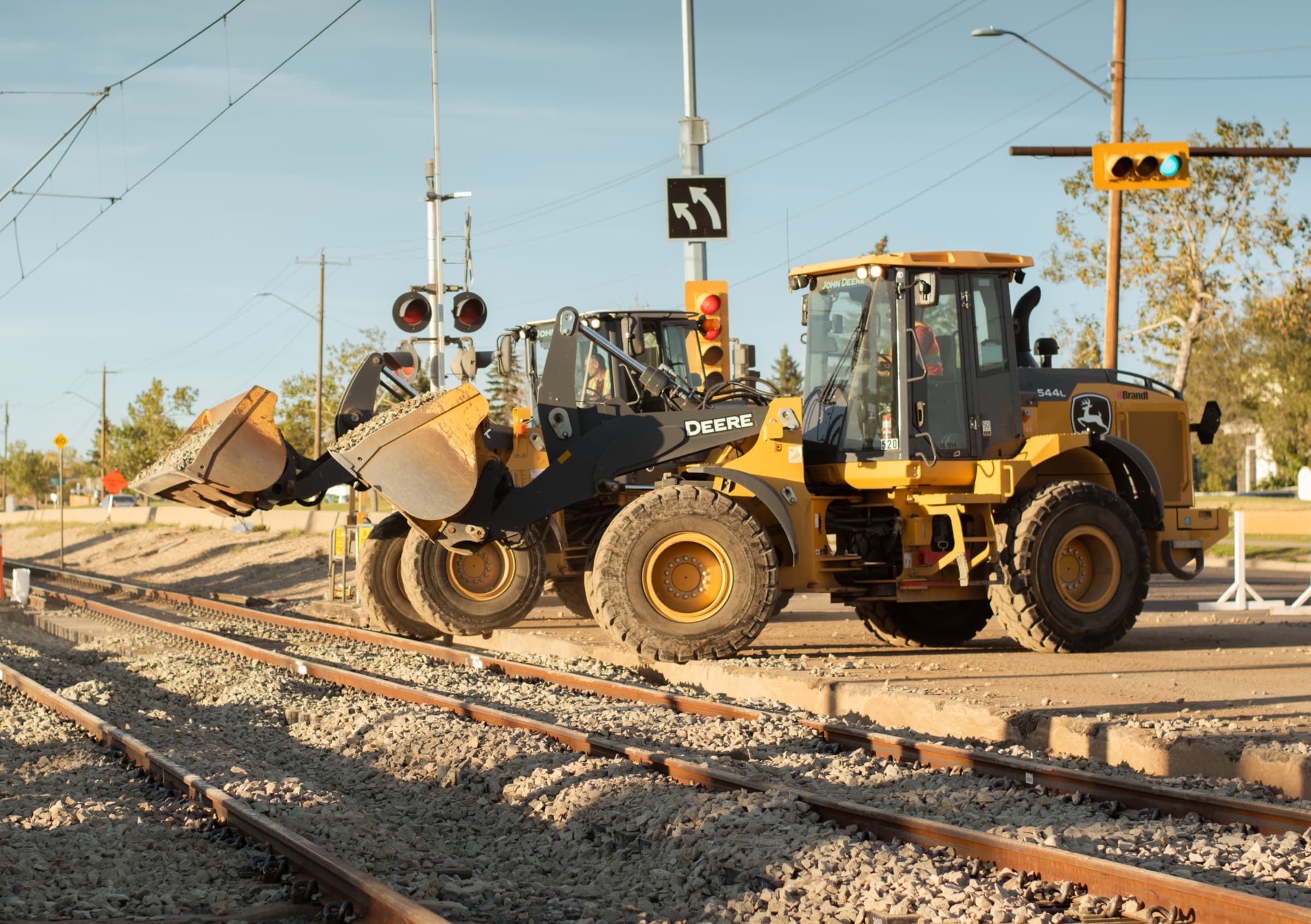 Front-end loaders handling materials beside railway track